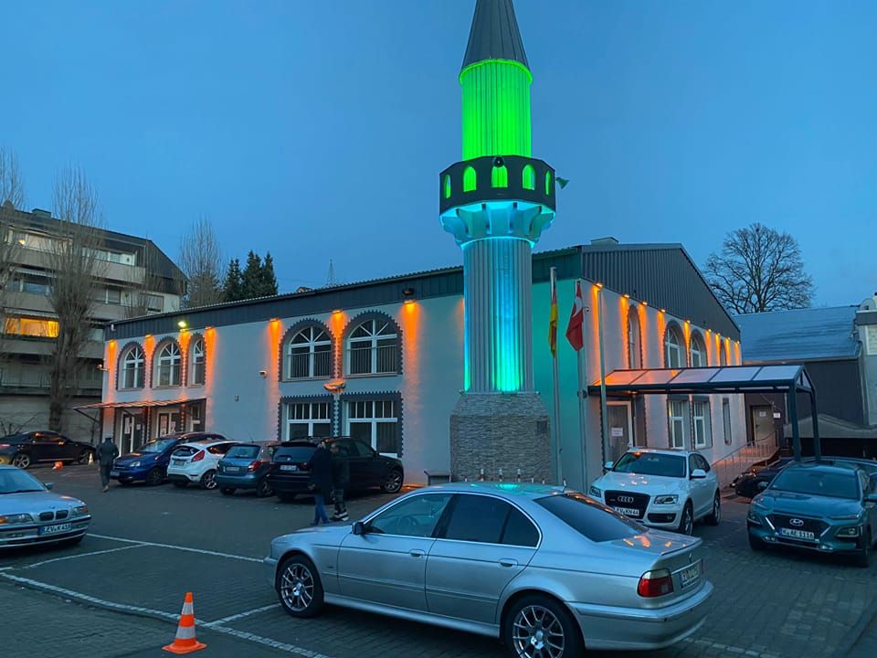 Außenansicht der Moschee mit beleuchtetem Minarett